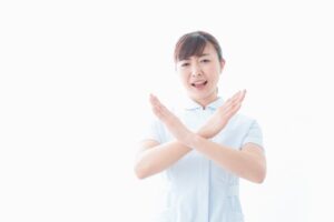 両腕でバツ印のポーズをとる女性看護師