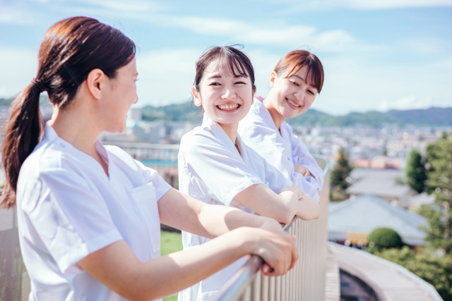 3人の女性看護師が屋上で談笑している写真