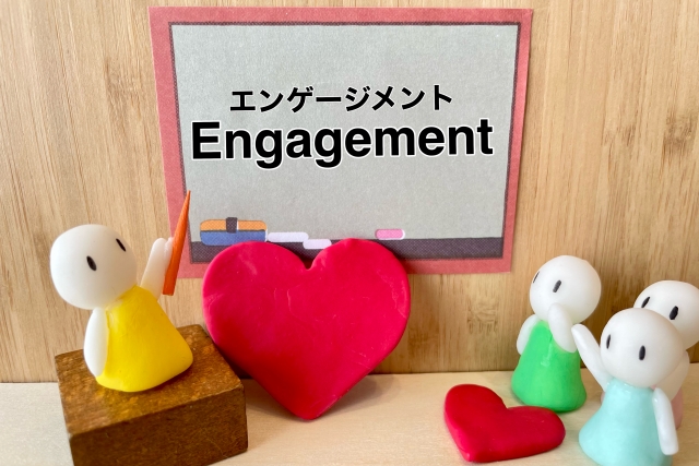 先生役の人形が黒板に書かれた「Engagement」の文字を指しているイラスト