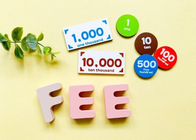 模型の紙幣と硬貨、「FEE」と書かれたイラスト