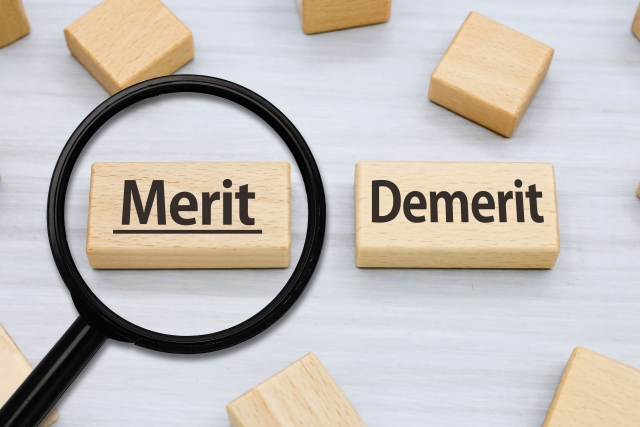 「Merit」「Demerit」と書かれた2つのブロックのうち「Merit」の方に虫眼鏡が置かれているイラスト