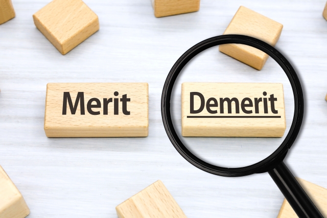 「Merit」「Demerit」と書かれた2つのブロックのうち「Demerit」の方に虫眼鏡が置かれているイラスト