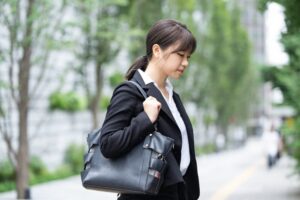 リクルートスーツを着たうつむく女性の画像