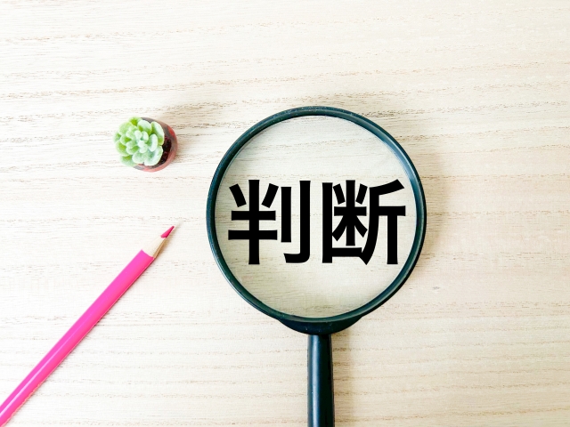 虫眼鏡のレンズに「判断」と書かれたイラスト